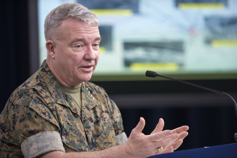 A man in a military uniform briefs reporters.