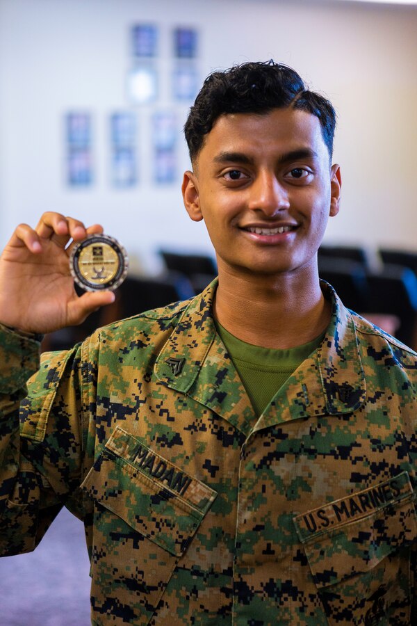 U.S. Marine Corps Cpl. Syedhafiz Madani, with Marine Corps Air Station (MCAS) Futenma, poses for a photo on Dec. 12, 2020, MCAS Futenma, Okinawa, Japan. Marines with MCAS Futenma processed over 1,800 pounds of mission critical perishable goods for two seperate flights to Osan Air Base, Korea. The Marines responsible for the crucial assistance were presented a challenge coin on behalf of the Army and Air Force Exchange Service CEO. (U.S. Marine Corps Photo by Cpl. Christopher A. Madero)