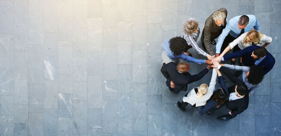 Group of professionals putting their hands into a circle