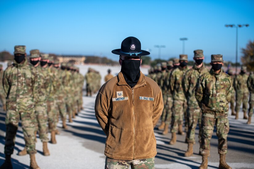 A Space Force training instructor stands at the front of a formation of service members.