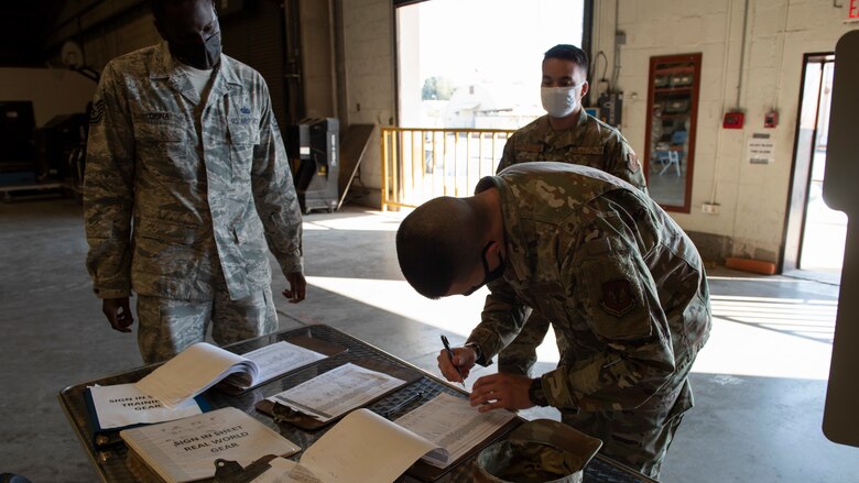 A warehouse NCO in-charge supervises Airmen checking-in to swap armor plates out.