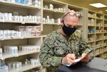 Lt. Cmdr. Jeremy Griswold, assistant department head for Naval Hospital Jacksonville�s pharmacy, reviews prescriptions at the outpatient pharmacy.