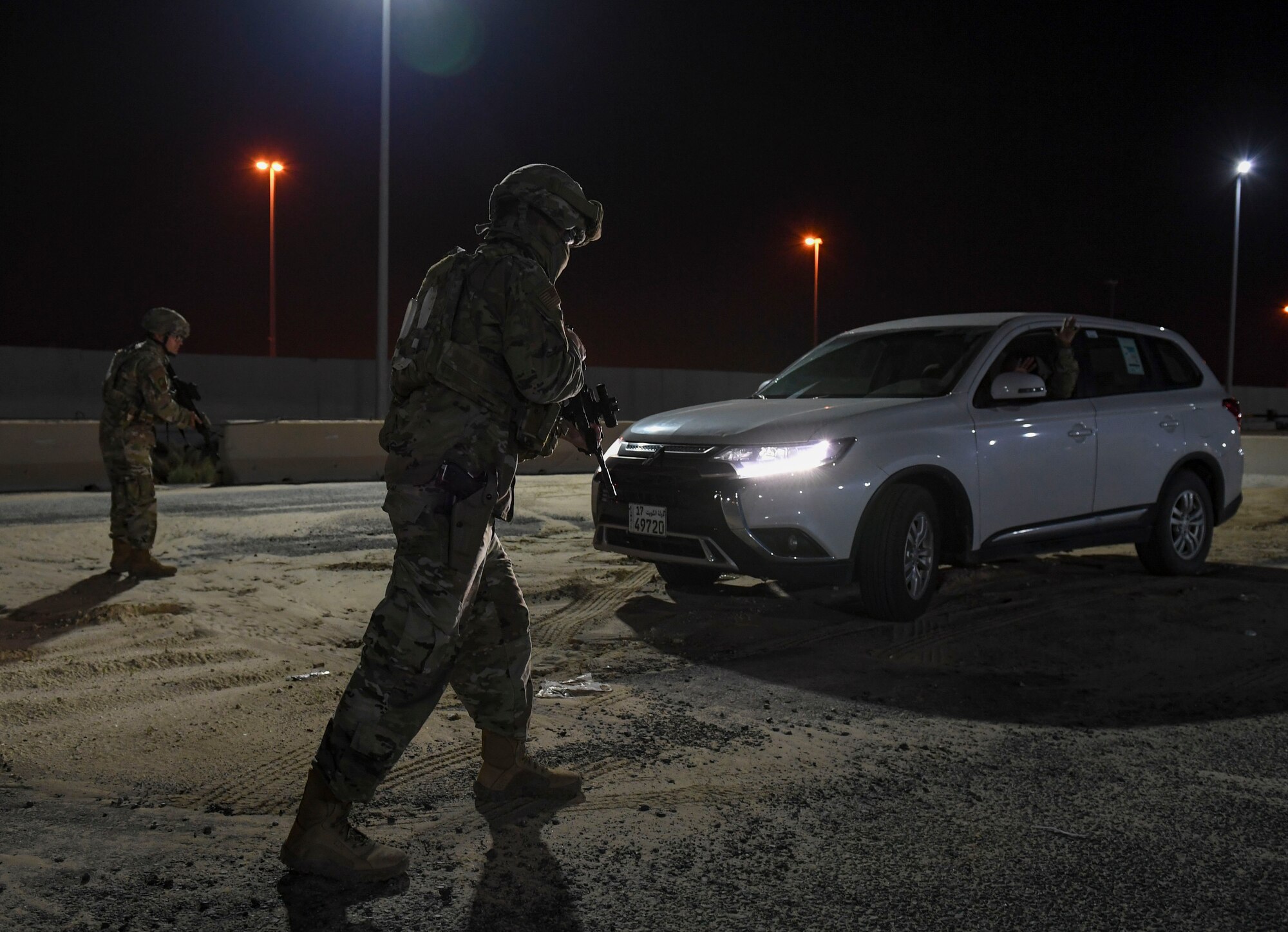 U.S. Air Force Senior Airmen Samuel Turley and Alberto Trinidad Marquez, 386th Expeditionary Security Forces Squadron response force leaders, initiate contact with a suspicious vehicle during the Marauder 21-02 exercise at Ali Al Salem Air Base, Kuwait, Dec. 8, 2020. ASAB units were tasked with responding to simulated threats and elevated Force Protection Condition levels. (U.S. Air Force photo by Senior Airman Monica Roybal)