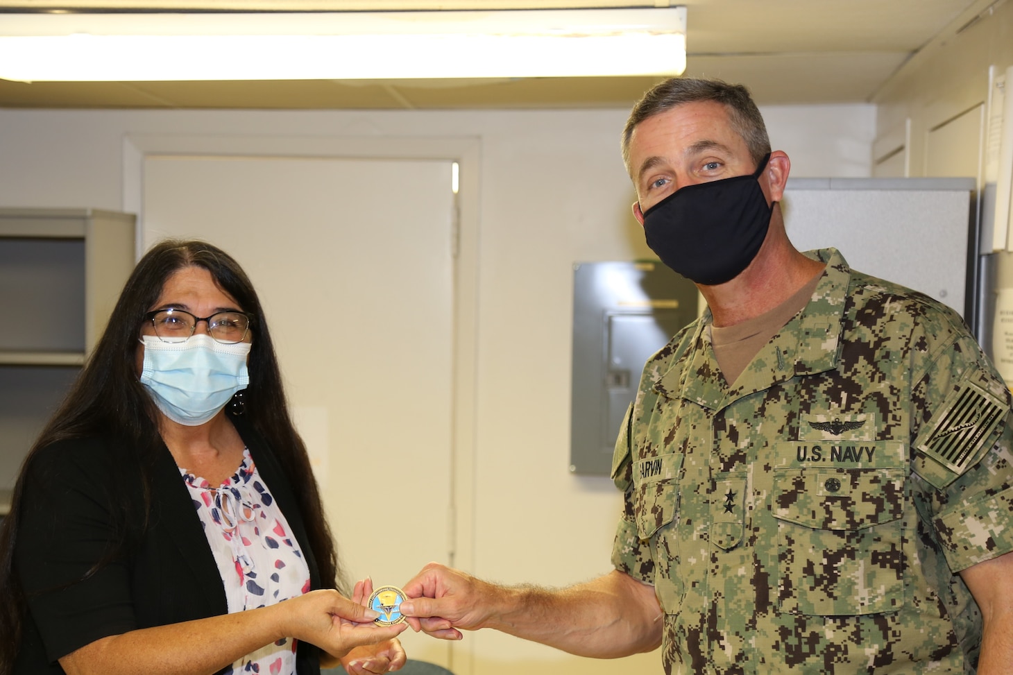 201110-N-YR423-2634 PENSACOLA, Fla. (Nov. 10, 2020) Commander, Naval Education and Training Command, Rear Adm. Peter Garvin, delivers a coin to Junior Civilian of the Quarter (COQ) selectee CeCe Castro during a site visit on Nov. 10, 2020. Castro, who serves as a program assistant for the Navy Advancement Center, was selected due to her superior performance in processing more than 170,000 exam answer sheets, adjudicating over 5,000 discrepancy corrections, and delivering customer service to important advancement stakeholders.  (U.S. Navy photo by Cheryl Dengler)