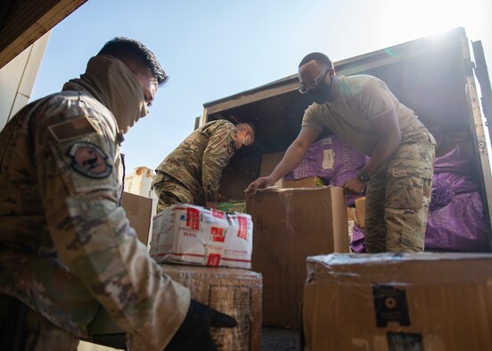 U.S. Air Force Staff Sgt. Phaysawan Sengphrachanh (left), 380th Expeditionary Security Forces Squadron Force Protection Hawkeye flight escort, Senior Airman Jesus Castrejon-Martinez (center), 380th Expeditionary Logistics Readiness Squadron log planner, and Staff Sgt. Rodney Anderson (right), 380th Expeditionary Force Support Squadron postal clerk, unload packages from a delivery truck at Al Dhafra Air Base (ADAB), United Arab Emirates, Dec. 8, 2020. ADAB personnel can volunteer to assist post office personnel with unloading, loading and sorting packages to their appropriate units. (U.S. Air Force photo by Senior Airman Bryan Guthrie)