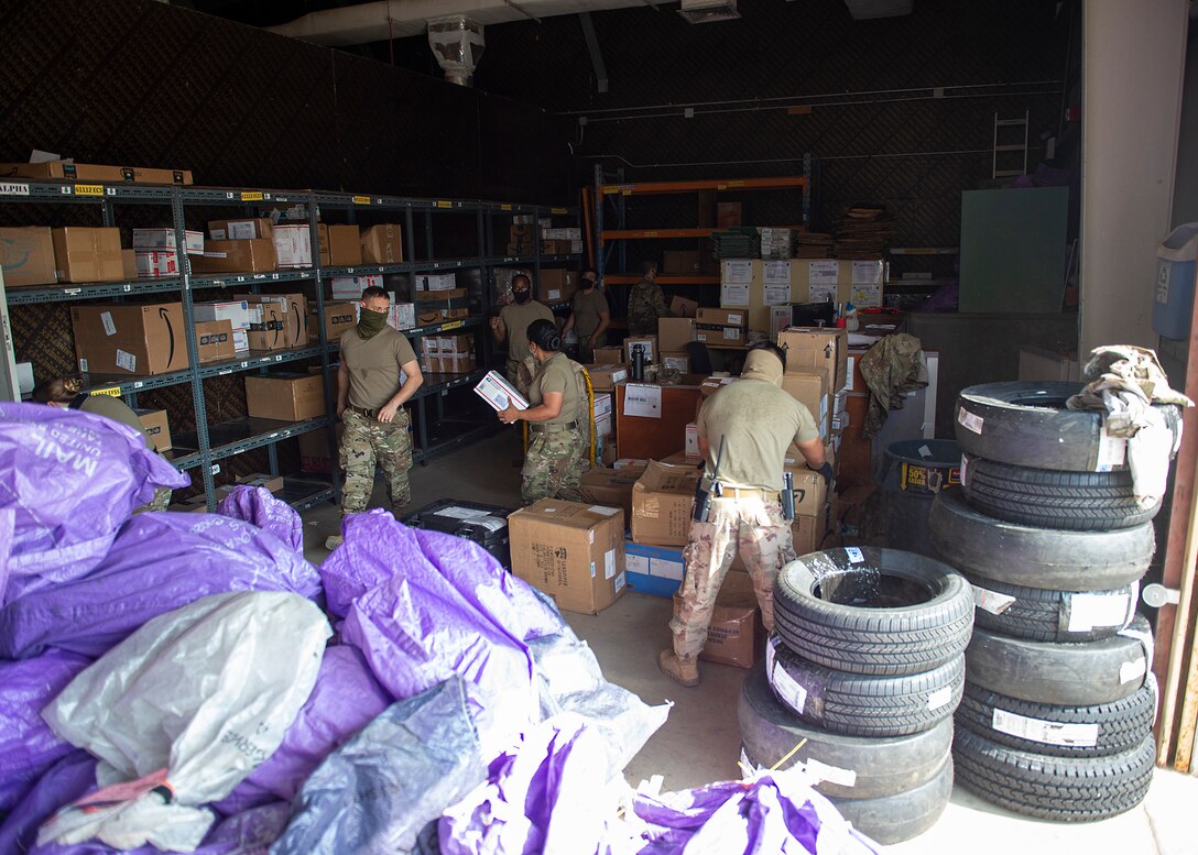 U.S. Air Force post office postal clerks and volunteers sort packages at Al Dhafra Air Base, United Arab Emirates, Dec. 8, 2020. Postal clerks issue money orders, sell stamps, apply postage with appropriate labels, and mail out letters in addition to being responsible for postal finance, mail distribution, and mail handling. Mail handling entails accepting, sorting, manifesting and dispatching all mail to and from the post office. (U.S. Air Force photo by Senior Airman Bryan Guthrie)