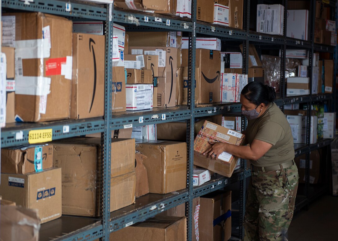 U.S. Air Force Tech. Sgt. Leolani Simpson, 380th Expeditionary Force Support Squadron postmaster, sorts packages at Al Dhafra Air Base (ADAB), United Arab Emirates, Dec. 8, 2020. As ADAB postmaster, Simpson is responsible for supervising logistics of mail delivery, directing post office retail operations, managing budgets, preparing reports about post office activities for regional management, overseeing all training and evaluations of post office staff to make sure personnel adhere to U.S. Postal Service (USPS) policies and educating the public on USPS regulations and services. (U.S. Air Force photo by Senior Airman Bryan Guthrie)