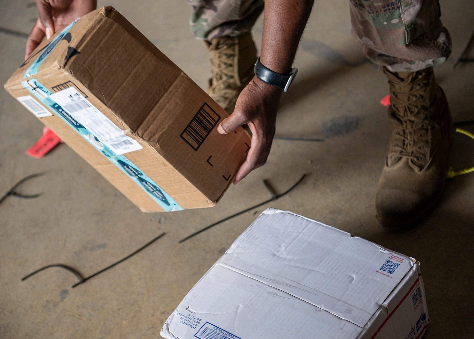 A U.S. Airman assigned to the 380th Expeditionary Force Support Squadron picks up a package at Al Dhafra Air Base (ADAB), United Arab Emirates, Dec. 8, 2020. Since October 2020, the ADAB post office has processed approximately 10,000 letters and packages weighing up to 126,000 pounds of mail. (U.S. Air Force photo by Senior Airman Bryan Guthrie)