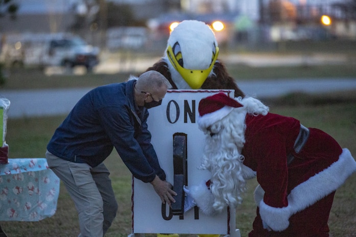 U.S. Marine Corps Col. Curtis V. Ebitz, left, the commanding officer of Marine Corps Air Station New River, and Santa flip the switch for the 8th annual tree lighting ceremony on Marine Corps Air Station New River, North Carolina, Dec. 6, 2020. The annual celebration brings service members and their families together to start the holiday season. (U.S. Marine Corps Photo by Lance Cpl. Isaiah Gomez)