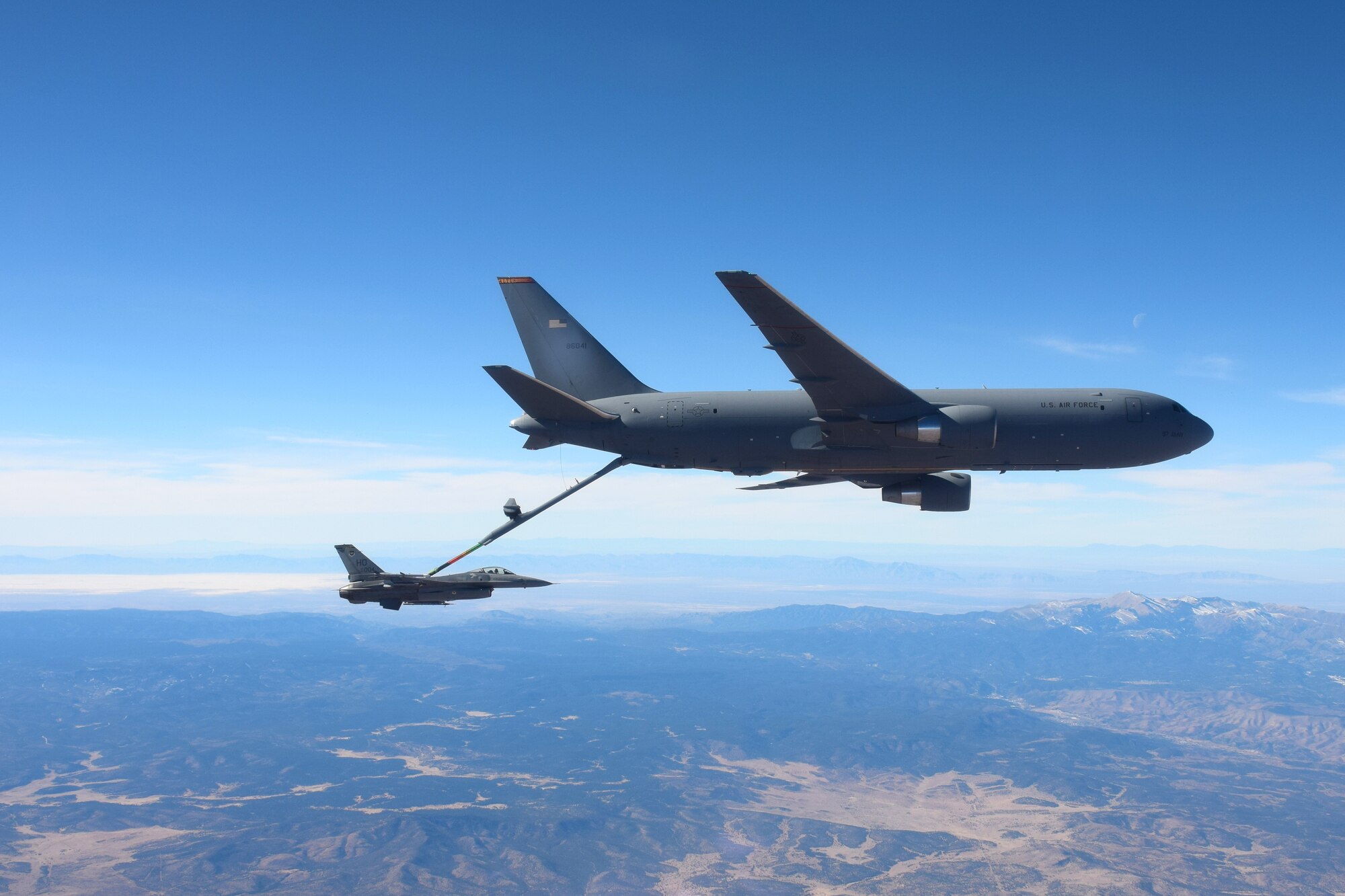 White Sands National Park can be seen in the distance at a KC-46 Pegasus from the 56th Air Refueling Squadron at Altus Air Force Base (AFB), Oklahoma, refuels an F-16 Fighting Falcon from the 49th Wing at Holloman AFB, New Mexico, December 7, 2020. Two KC-46s practiced air refueling operations over New Mexico with ten F-16s from Holloman AFB. (Courtesy photo by 1st Lt. Daniel Lee)