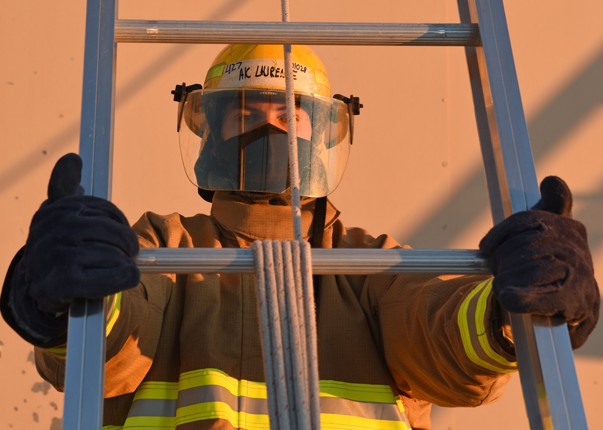 U.S. Air Force Airman 1st Class Zachary Laurence, 312th Training Squadron fire protection student, secures a ladder for his classmate to climb during a vertical ventilation training simulation at the Louis F. Garland Department of Defense Fire Academy on Goodfellow Air Force Base, Texas, Dec. 10, 2020. The vertical ventilation block was a 20-training-day section to a 68-training-day course that focused on fundamental fire fighter skills and partner safety. (U.S. Air Force photo by Senior Airman Abbey Rieves)