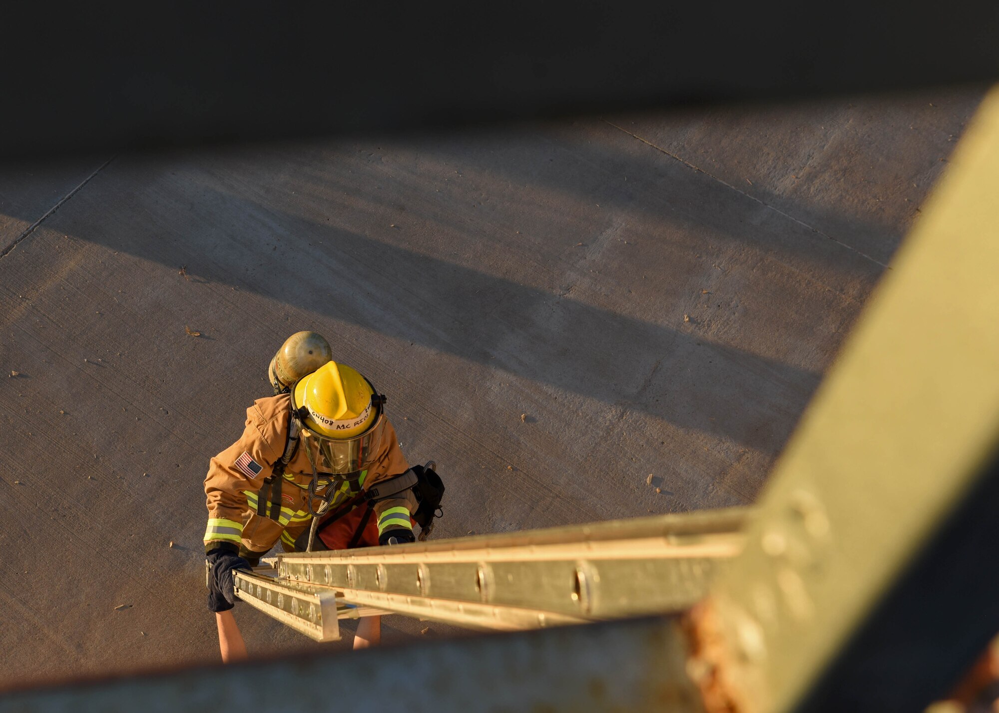U.S. Air National Guard Airman 1st Class Geovannie Rios-Santos, 312th Training Squadron fire protection student, ascends a ladder to an artificial rooftop during a vertical ventilation training exercise located at the Louis F. Garland Department of Defense Fire Academy on Goodfellow Air Force Base, Texas, Dec. 10, 2020. Rios-Santos was one of the 12 students in the joint environment to be trained with hands-on advantages. (U.S. Air Force photo by Senior Airman Abbey Rieves)