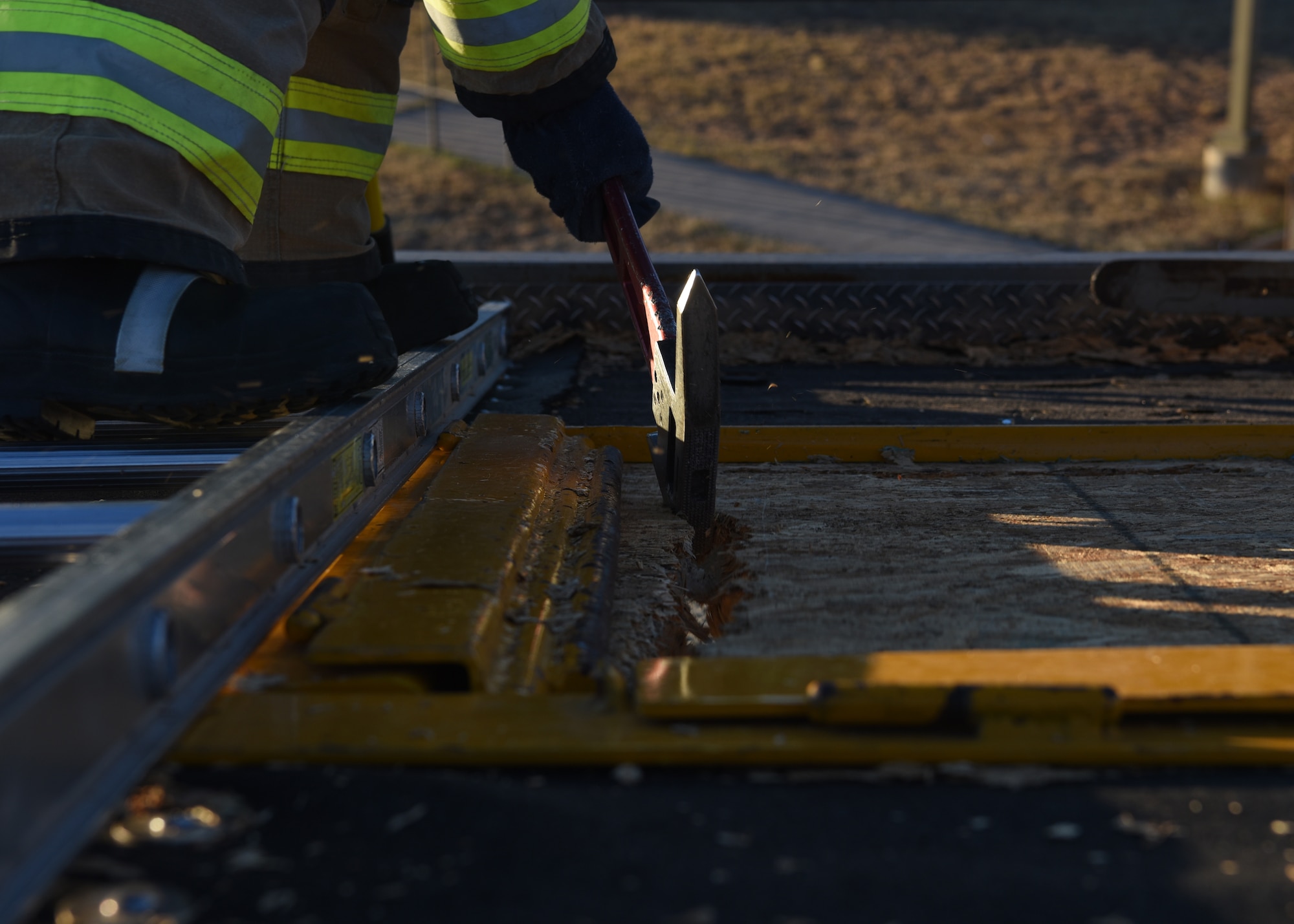 U.S. Air Force Airman Nathan Lott, 312th Training Squadron fire protection student, cuts a 4x4 foot exhaust port in an artificial rooftop during his vertical ventilation training exercise at the Louis F. Garland Department of Defense Fire Academy on Goodfellow Air Force Base, Texas, Dec. 110, 2020. Lott’s cut position was decided by multiple factors, but the most important was wind direction and location of the simulated fire. The cutting pattern was started furthest from the egress point and worked back towards the ladder to prevent the firefighters from cutting off their escape path should new hazards arise.  (U.S. Air Force photo by Senior Airman Abbey Rieves)