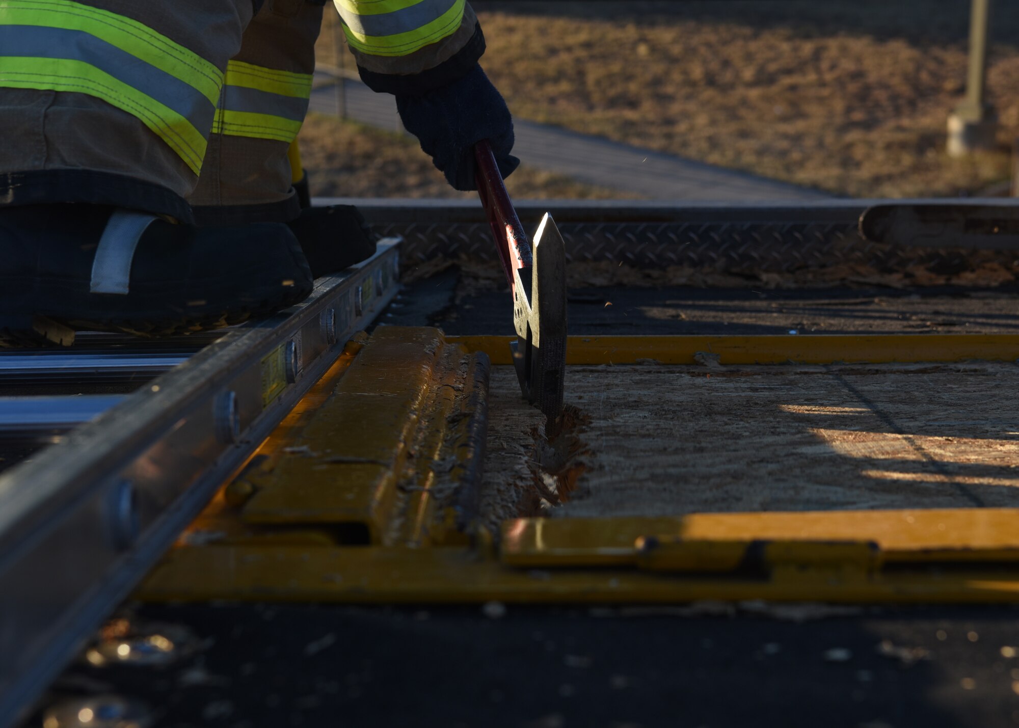 U.S. Air Force Airman Nathan Lott, 312th Training Squadron fire protection student, cuts a 4x4 foot exhaust port in an artificial rooftop during his vertical ventilation training exercise at the Louis F. Garland Department of Defense Fire Academy on Goodfellow Air Force Base, Texas, Dec. 110, 2020. Lott’s cut position was decided by multiple factors, but the most important was wind direction and location of the simulated fire. The cutting pattern was started furthest from the egress point and worked back towards the ladder to prevent the firefighters from cutting off their escape path should new hazards arise.  (U.S. Air Force photo by Senior Airman Abbey Rieves)