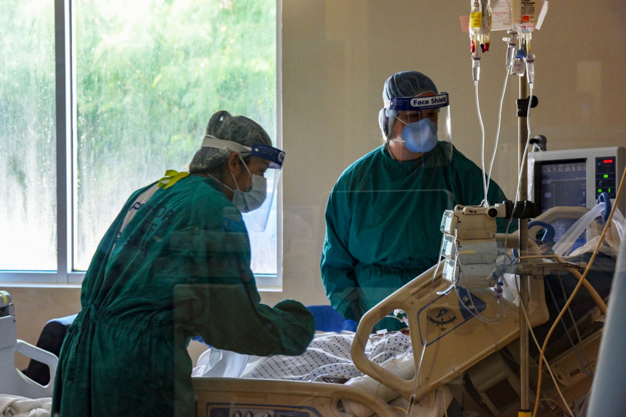 Two military nurses attend to a patient.