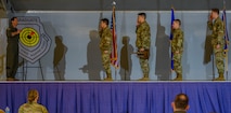 Airmen salute on stage.