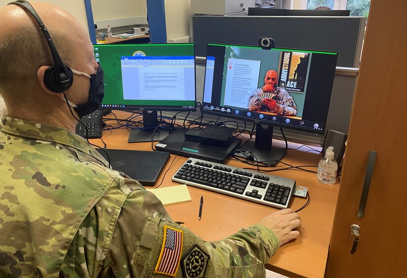 A soldier wears a face mask while participating in a digital conference call.