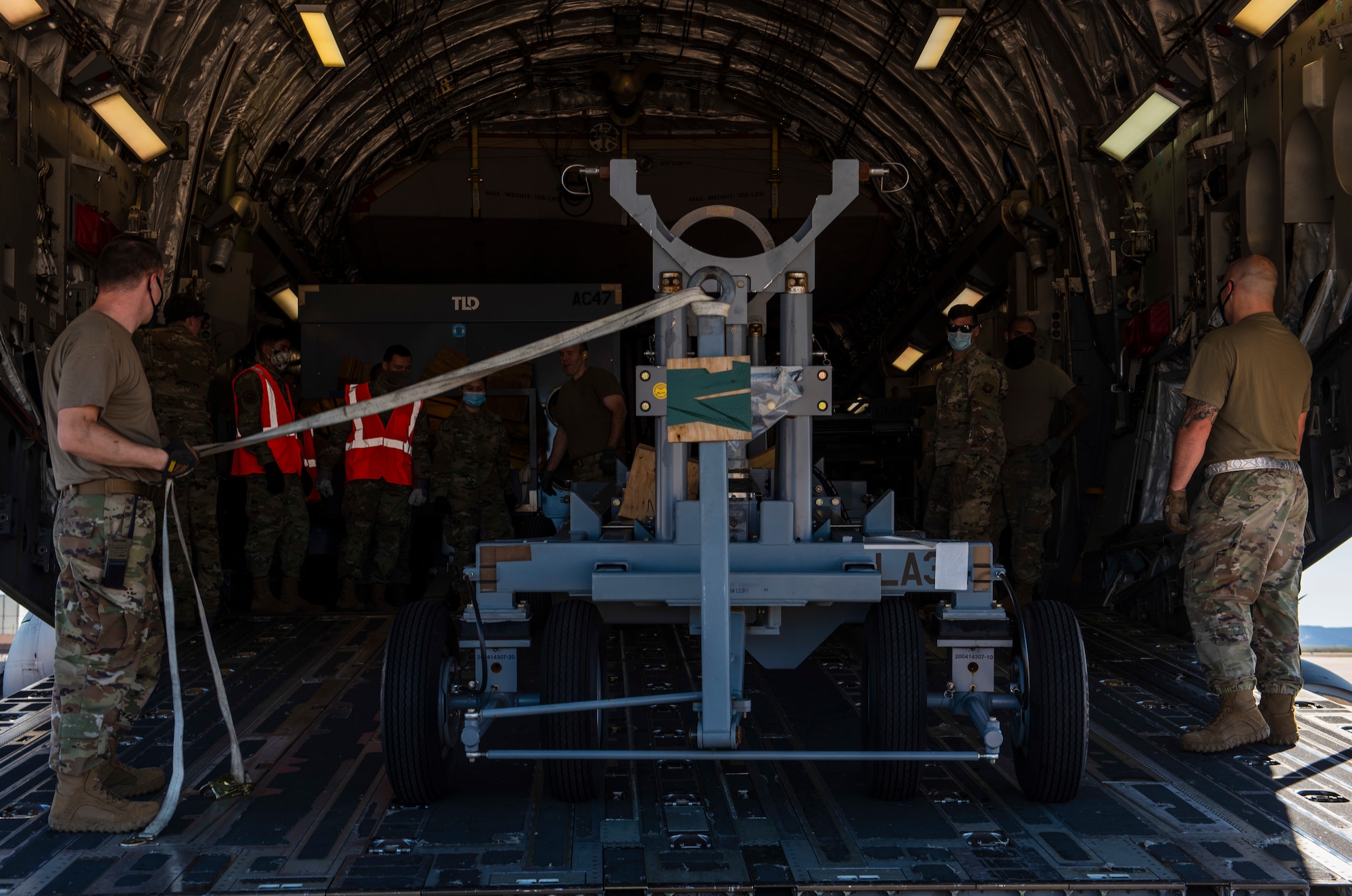 Airmen assigned to the 7th Logistics Readiness Squadron air transportation function and 7th LRS augmentees prepare to unload cargo from a C-17 Globemaster III at Dyess Air Force Base, Texas, Nov. 25, 2020.