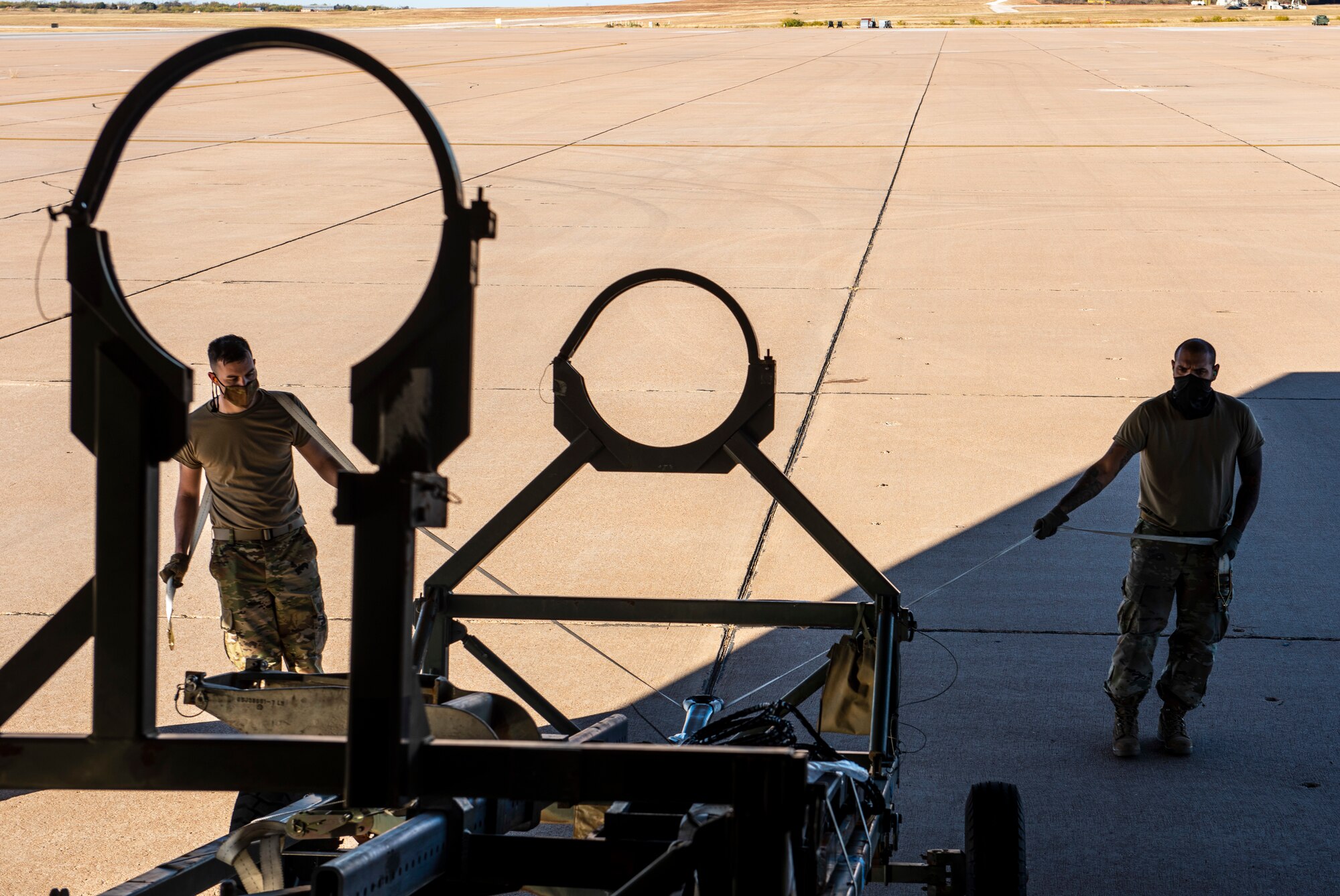 Senior Airman Joseph Salafia, 7th Logistics Readiness Squadron air transportation function passenger service specialist, left, and Staff Sgt. Roberto Rodriguez, 7th LRS air transportation function NCO in charge of ramp services, right, unload cargo from a C-17 Globemaster III at Dyess Air Force Base, Texas, Nov. 25, 2020.