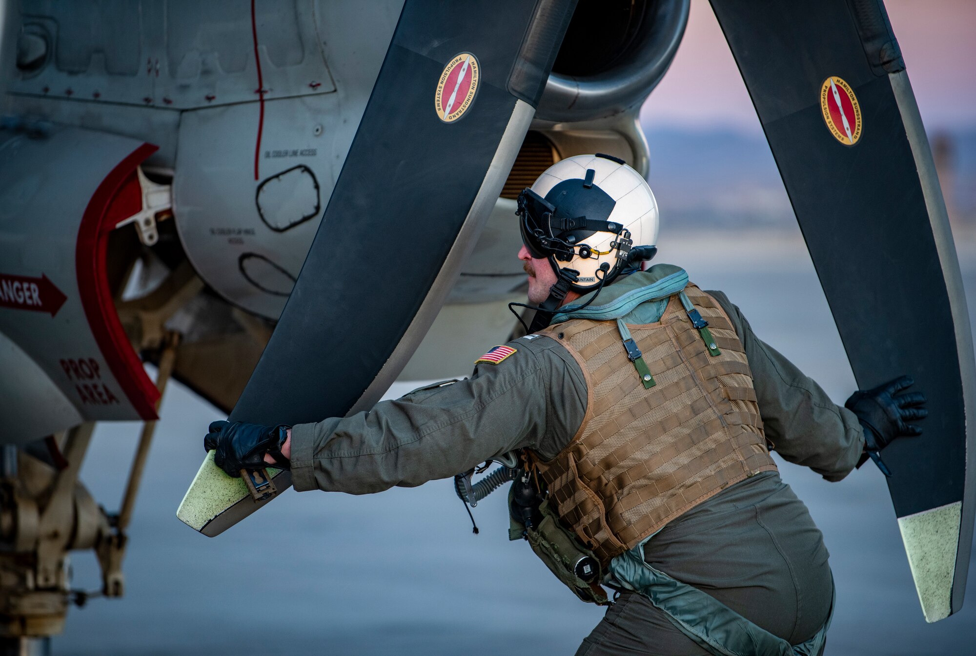 A U.S. Navy pilot checks propellers on aircraft.