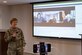 Image of an Airman talking in front of a screen.
