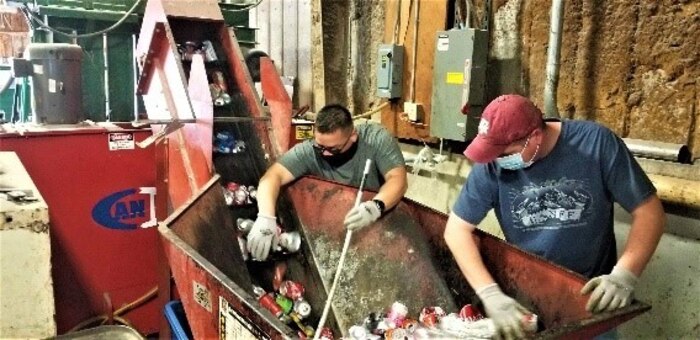 Jesse Vasquez and Mickey Lyles, City of Altus employees at the 97th Air Mobility Wing Recycling Center on Altus Air Force Base, Oklahoma, sort cans to be crushed at the Altus Air Force Base recycling center Dec. 11, 2020. (U.S. Air Force photo by Judy Mott)