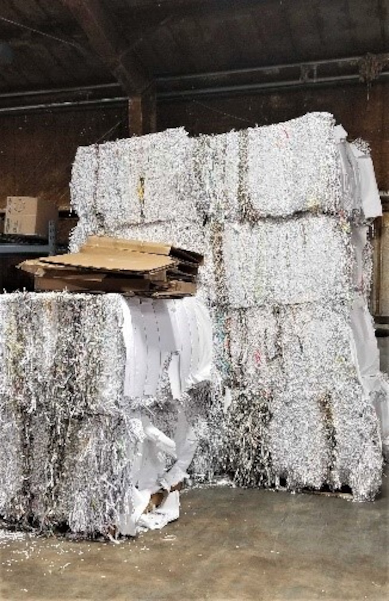 Large bales of shredded white paper, newsprint, and magazines sit ready to be transported at the 97th Air Mobility Wing Recycling Center on Altus Air Force Base, Oklahoma, Dec. 10, 2020. Everything that comes through the center comes back to the base in the form of dollars to pay for the center’s operation and maintenance expenses. (U.S. Air Force photo by Judy Mott)