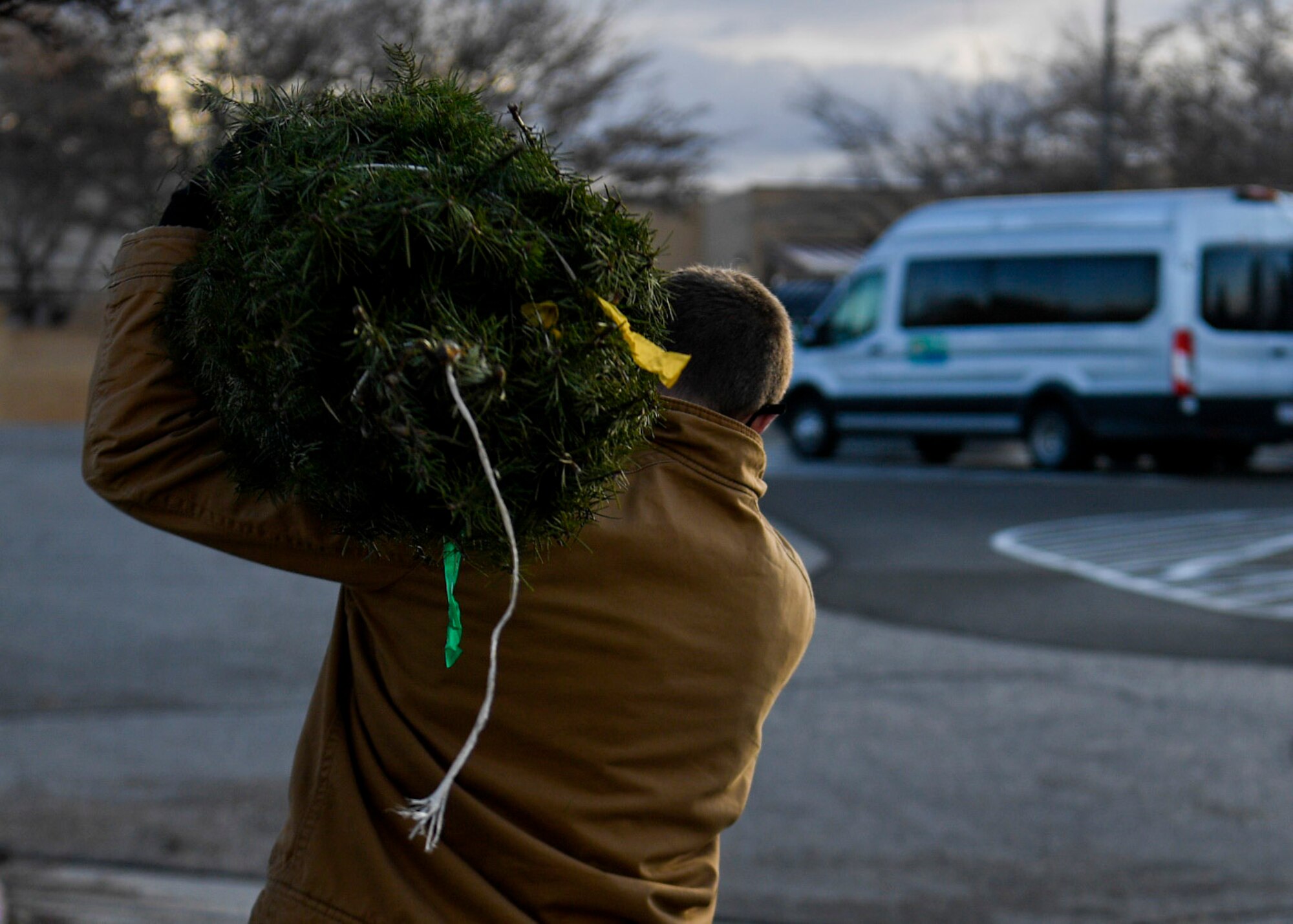 An Airman carries a tree.