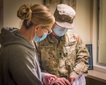 Spc. Devin Turchetta, 1048th Medium Truck Company, verifies COVID-19 antigen test kit delivery information with a health center worker at Loomis Chaffee School in Windsor, Connecticut, Dec. 11, 2020. The Connecticut National Guard delivered 102,280 kits to 212 nursing homes in one week in support of a Connecticut Department of Public Health effort to maximize testing availability and efficiency for people living in congregate settings.