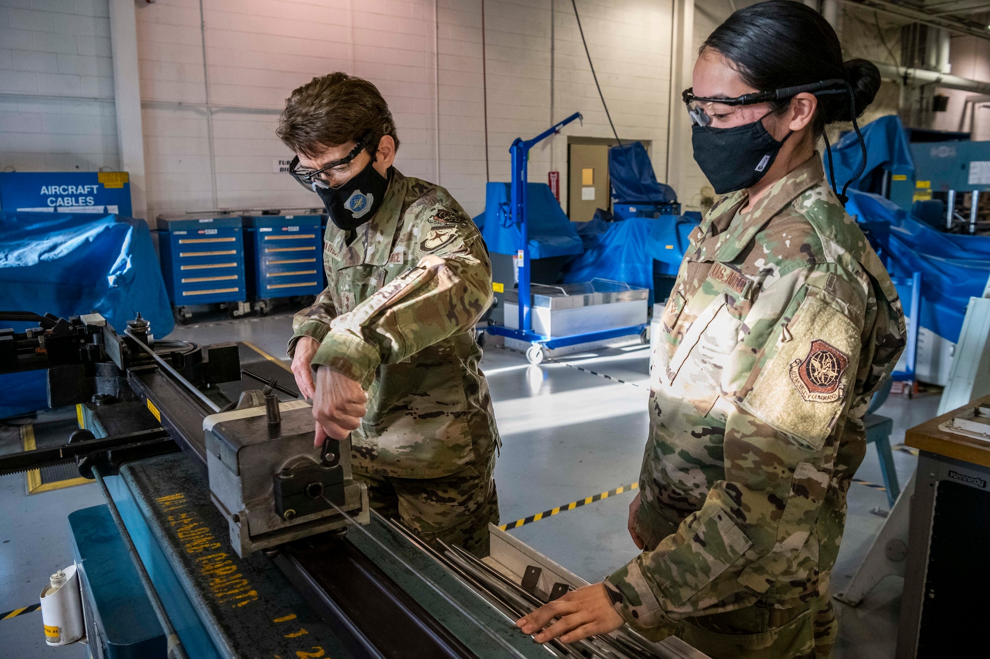Airman 1st Class Sheila Tilden, 436th Maintenance Squadron aircraft structural maintenance journeyman, shows Gen. Jacqueline Van Ovost, Air Mobility Command commander, how to manufacture tubing for aircraft at Dover Air Force Base, Delaware, Dec. 8, 2020. During her visit, Van Ovost experienced firsthand how Dover AFB supports AMC’s priority of enhancing full-spectrum readiness and developing innovative, multi-capable Airmen. (U.S. Air Force photo by Senior Airman Christopher Quail)