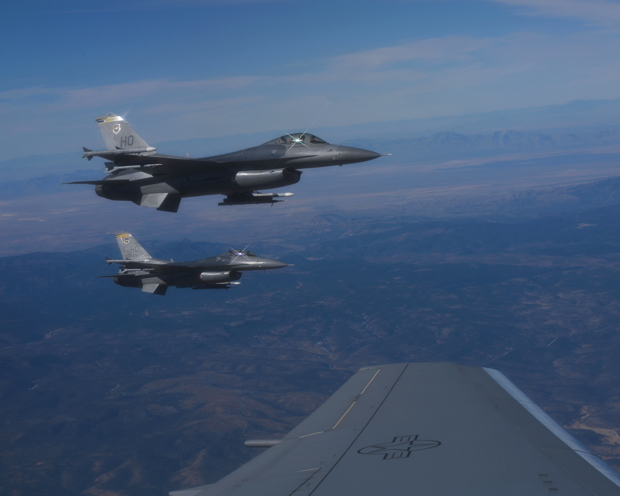 Over the mountains of southern New Mexico, two F-16 Fighting Falcons from the 49th Wing at Holloman Air Force Base (AFB), New Mexico, fly off the left wing of a KC-46 Pegasus from the 56th Air Refueling Squadron (ARS) at Altus AFB, Oklahoma, December 7, 2020. This is the first time KC-46s from the 56 ARS have worked with fighter aircraft. (U.S. Air Force photo by Tech. Sgt. Robert Sizelove)