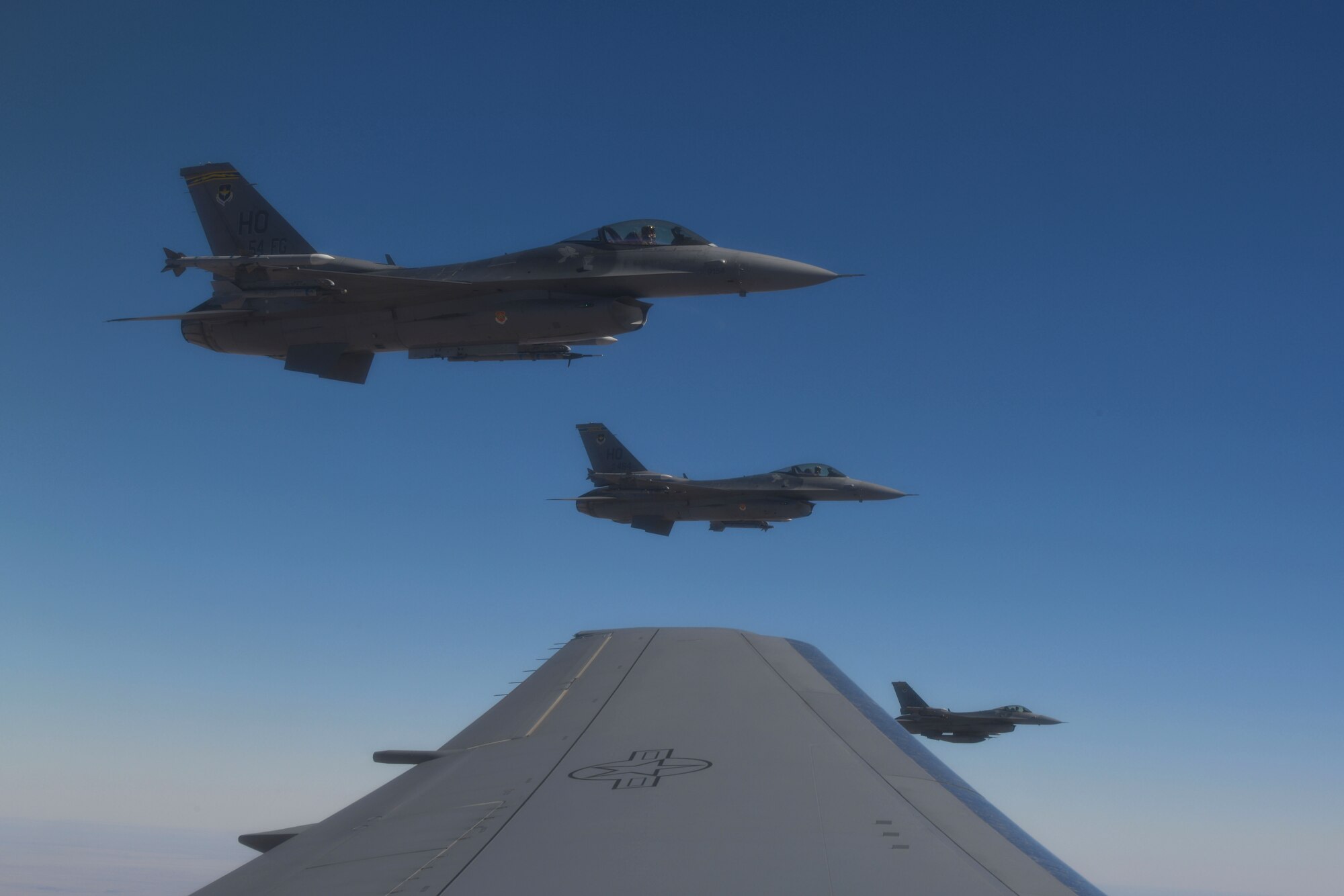 Three F-16 Fighting Falcons from the 49th Wing at Holloman Air Force Base (AFB), New Mexico, fly off the left wing of a KC-46 Pegasus from the 56th Air Refueling Squadron at Altus AFB, Oklahoma, December 7, 2020. During the training sortie over southern New Mexico, two KC-46s transferred over 65 thousand pounds of fuel to ten F-16s from Holloman AFB. (U.S. Air Force photo by Tech. Sgt. Robert Sizelove)