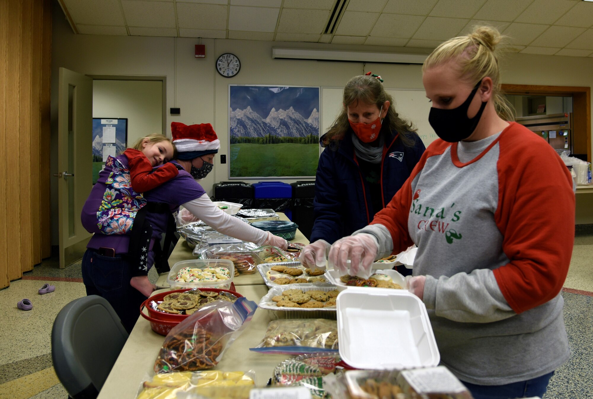 Three people preparing cookie boxes