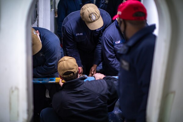Sailors assigned to the Wasp-class amphibious assault ship USS Kearsarge (LHD 3) fasten metal shoring to the bulkhead during a flooding drill Dec. 10, 2020.