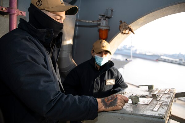 Boatswain's Mate Seaman Isaac Pipes, and Boatswain's Mate 2nd Class Brianna Alvarado, man boat davit crane controls during a man overboard drill aboard the Wasp-class amphibious assault ship USS Kearsarge (LHD 3) on Dec. 10, 2020.