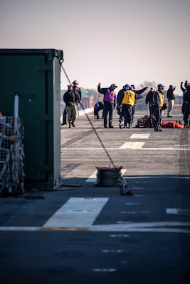 Sailors assigned to the Wasp-class amphibious assault ship USS Kearsarge (LHD 3) search for foreign object debris on the flight deck Dec. 10, 2020.
