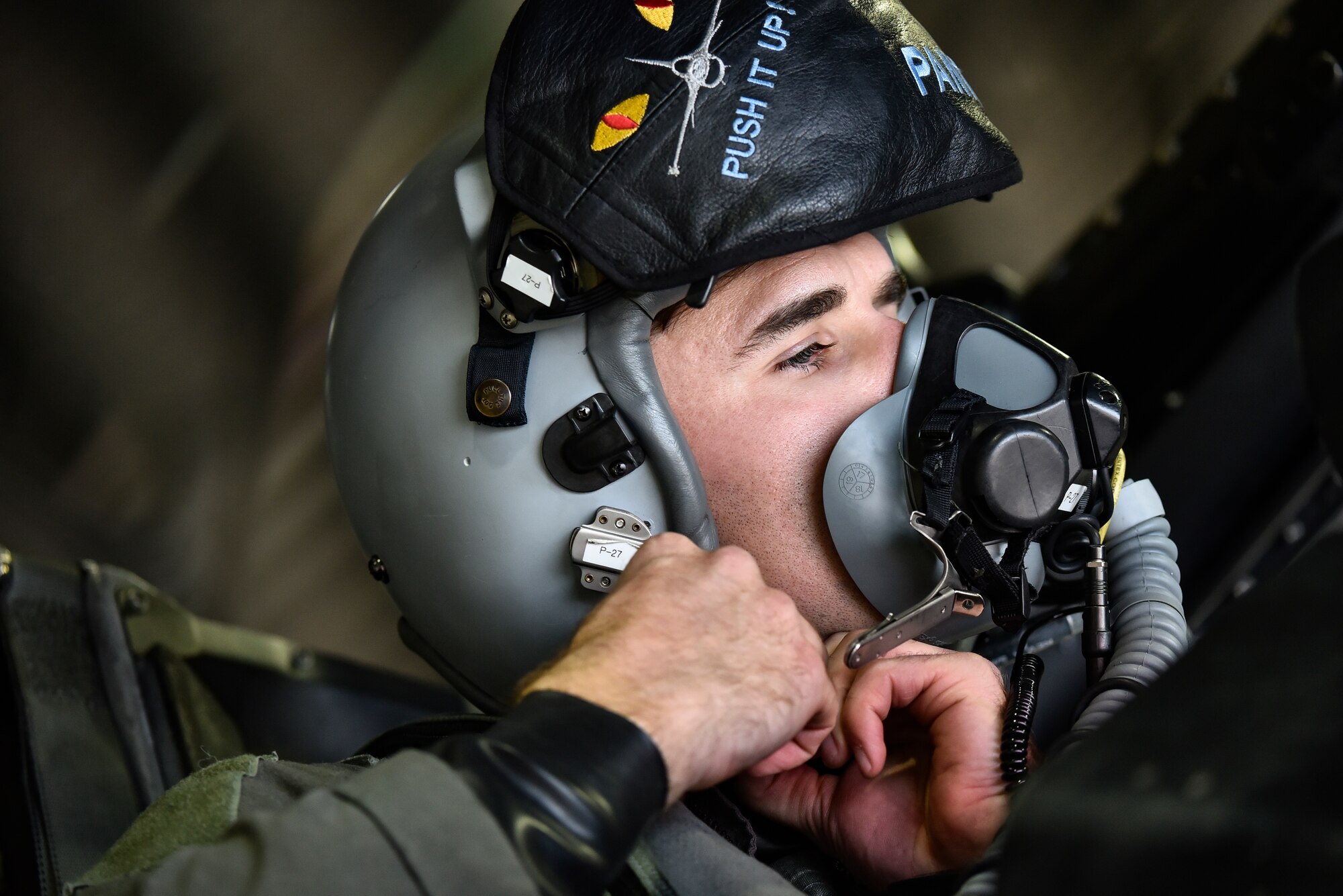 A pilot fastens his helmet.