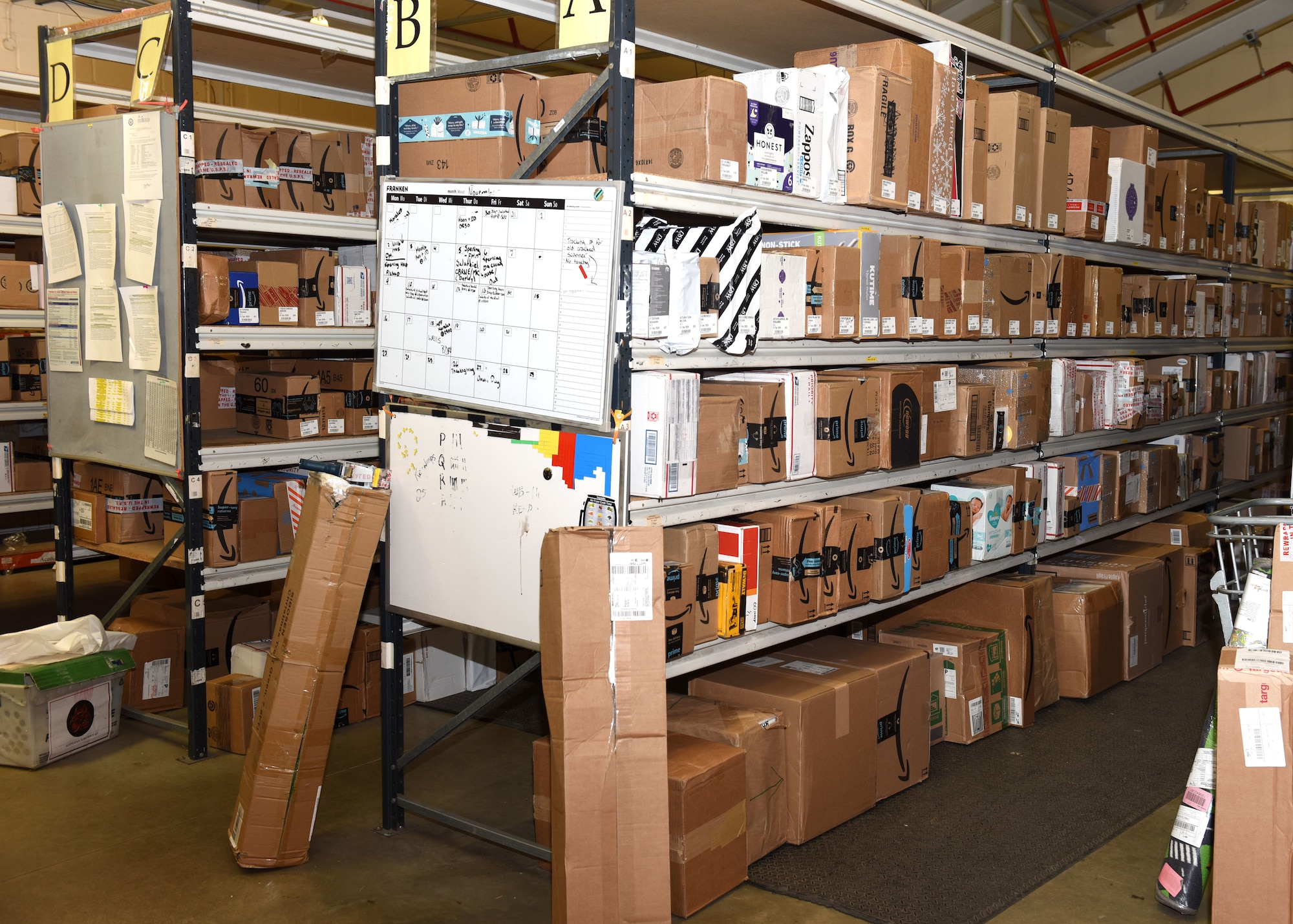 Incoming packages fill all the shelves at the post office at Royal Air Force Mildenhall, England, Dec. 1, 2020. Once packages have been scanned into the system, customers are notified and asked to pick up their items as soon as possible, to make space for other boxes. The post office has seen a 40 percent increase in packages during the coronavirus pandemic, and an even bigger increase over the start of the holiday season. (U.S. Air Force photo by Karen Abeyasekere)