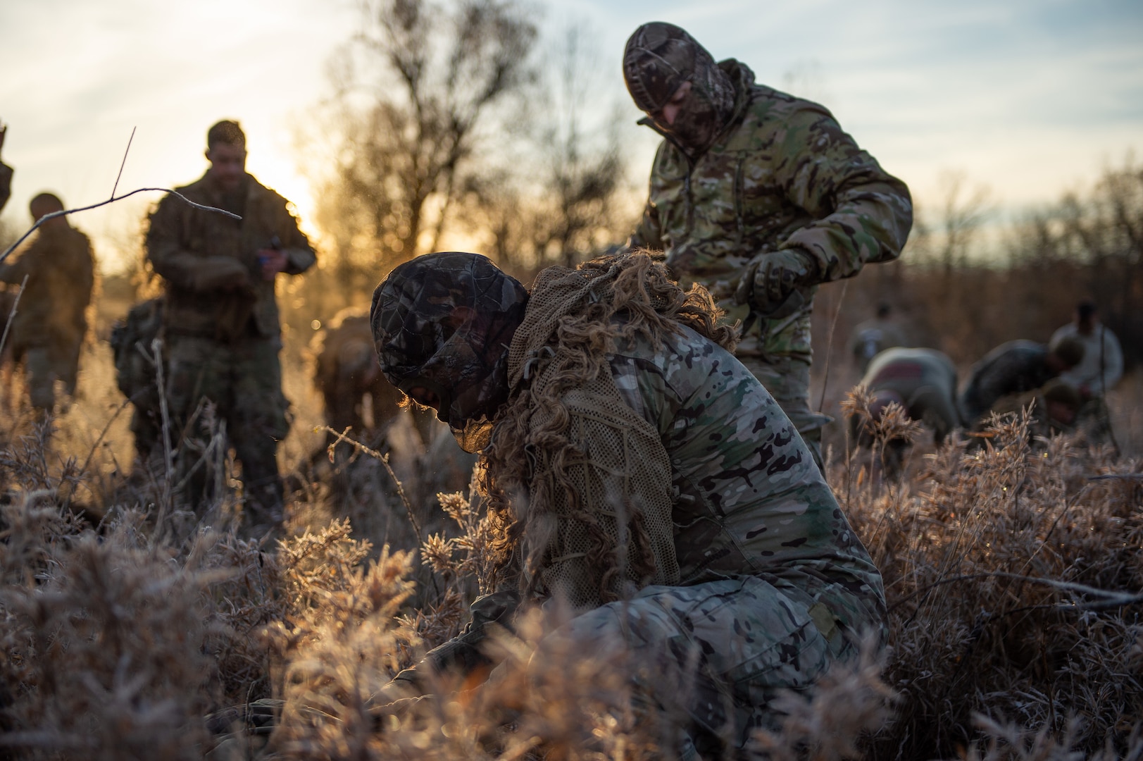 Staff Sgt. Demetrios Iannios, All Guard Sniper Team, California National Guard, leans down to double-check his equipment as his partner, Staff Sgt. Erik Vargas, adjusts his ghillie suit before they transform into the stealthiest hunters you never saw coming during the Stalk event on Dec. 9, 2020, at the 50th Winston P. Wilson and 30th Armed Forces Skill at Arms Meeting Sniper Championships at the Fort Chaffee Joint Maneuver Training Center. The championships were hosted by the National Guard Marksmanship Training Center with the help of the U.S. National Guard Sniper School Dec. 4-10, 2020.