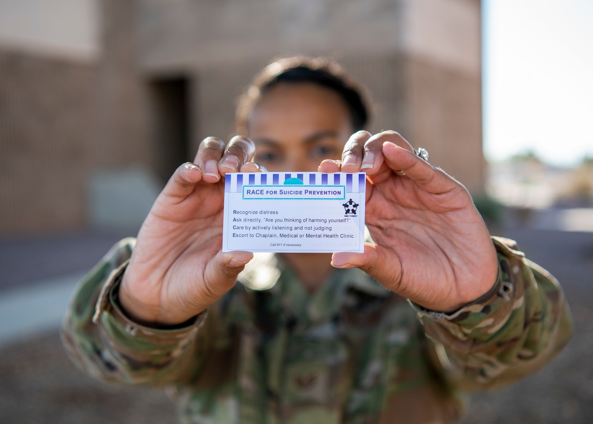 Picture of woman holding up suicide prevention business card