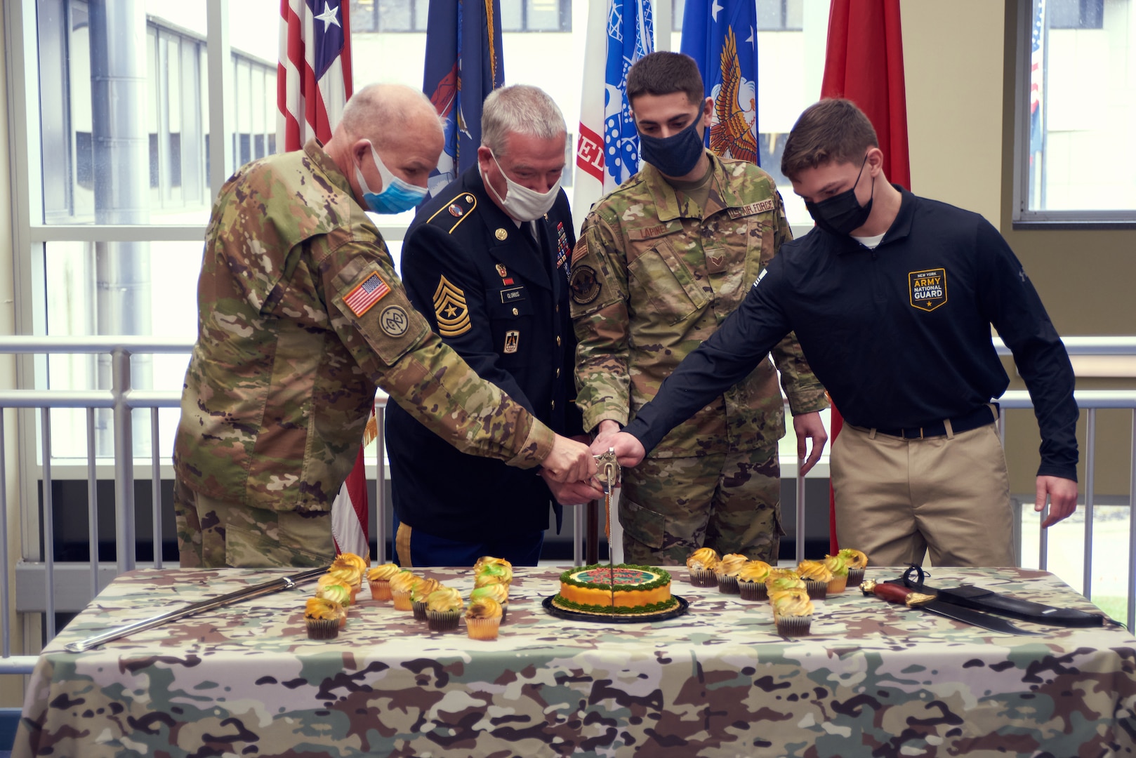 Army Maj. Gen. Raymond Shields, the adjutant general of New York; retired Army Sgt. Maj. Christian Glorius; Air Force Senior Airman Caleb Lapinel and Army Pvt. Malachy McGarry cut the National Guard birthday cake during a ceremony celebrating the 384th birthday of the National Guard at New York National Guard Joint Force Headquarters, Latham, N.Y., Dec. 14, 2020.