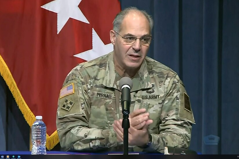 A man wearing a military uniform speaks into a microphone.