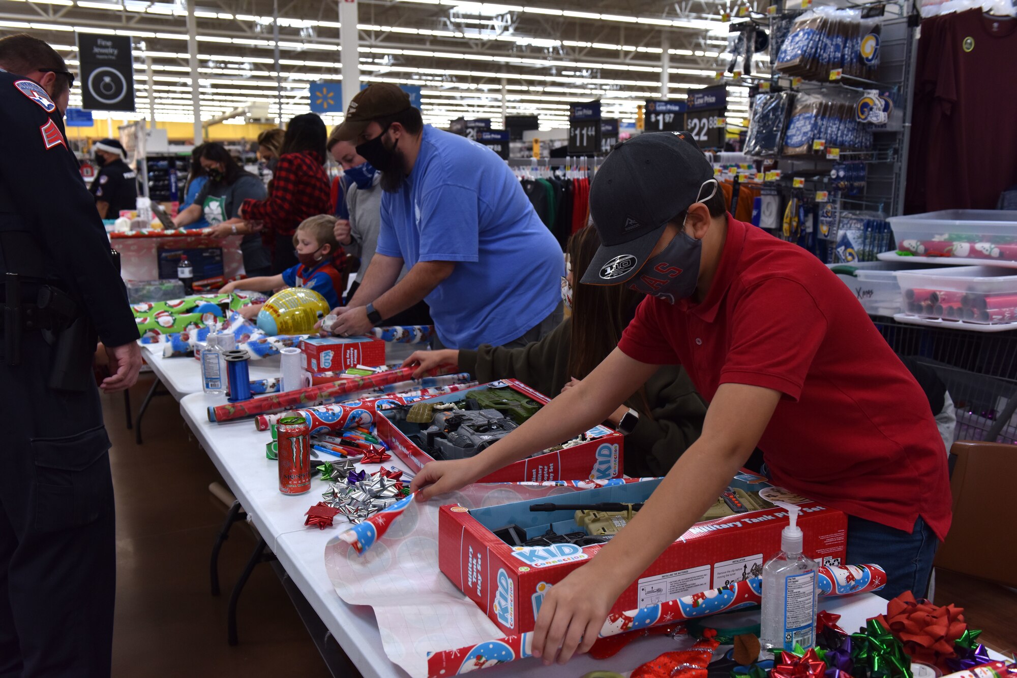 Volunteers wrap gifts that participants of the 13th Annual Operation Blue Santa picked during the event in San Angelo, Texas, Dec. 12, 2020. Family members of the police officers helped participants pick out gifts, wrap presents or provide refreshments. (U.S. Air Force photo by Staff Sgt. Seraiah Wolf)