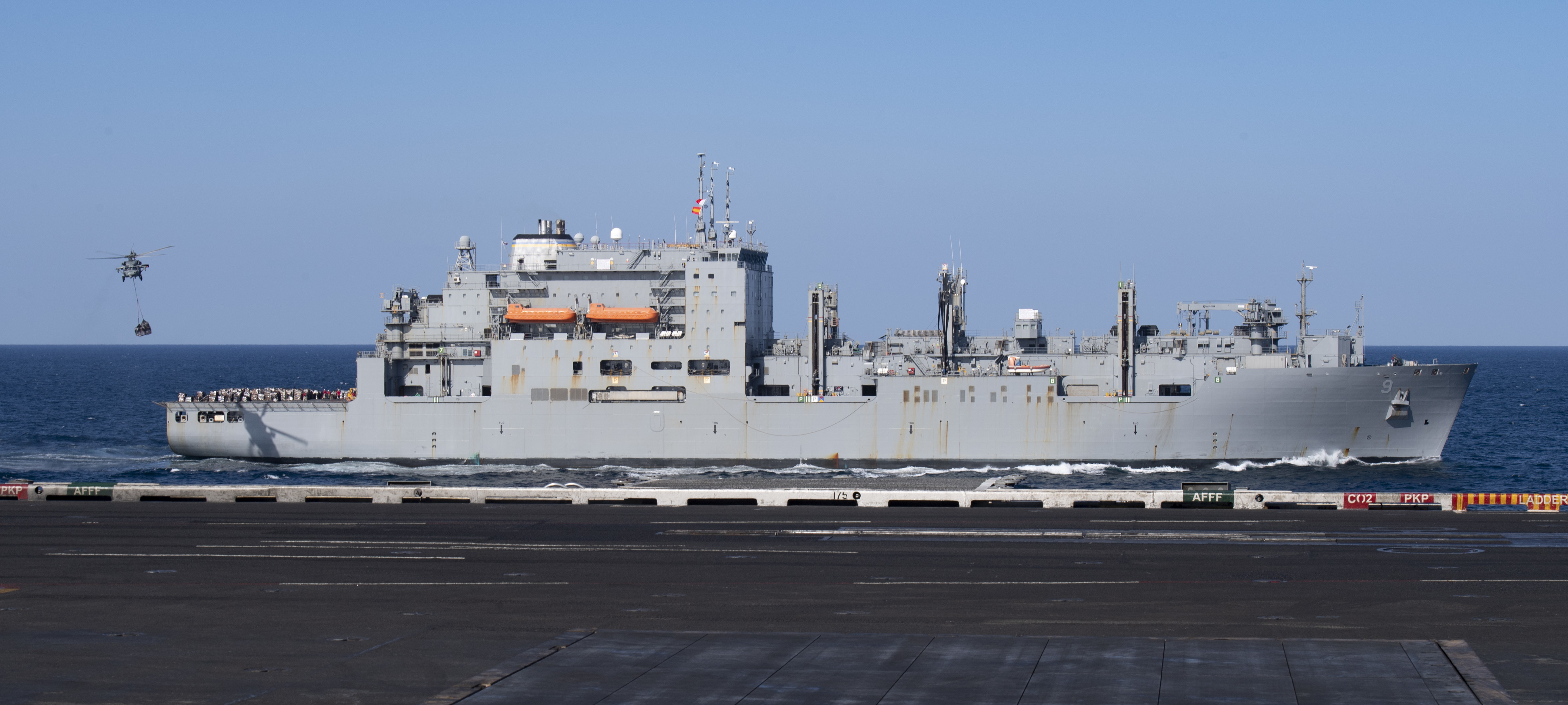 USNS Matthew Perry (T-AKE-9) steams alongside USS Nimitz (CVN 68) during a replenishment-at-sea.