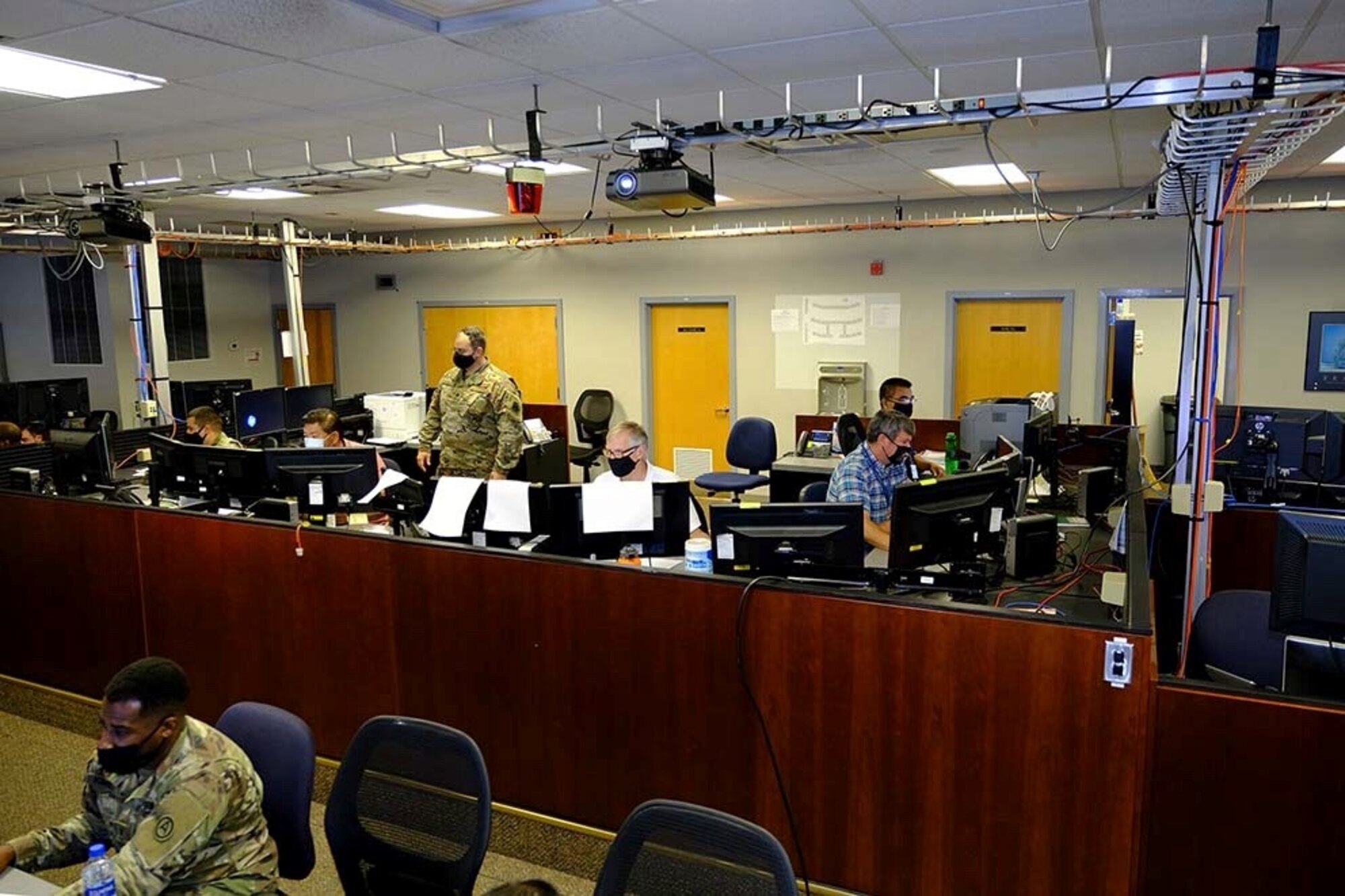 Photo of U.S. Air Force Airmen, civilians and contractors sitting at computers.