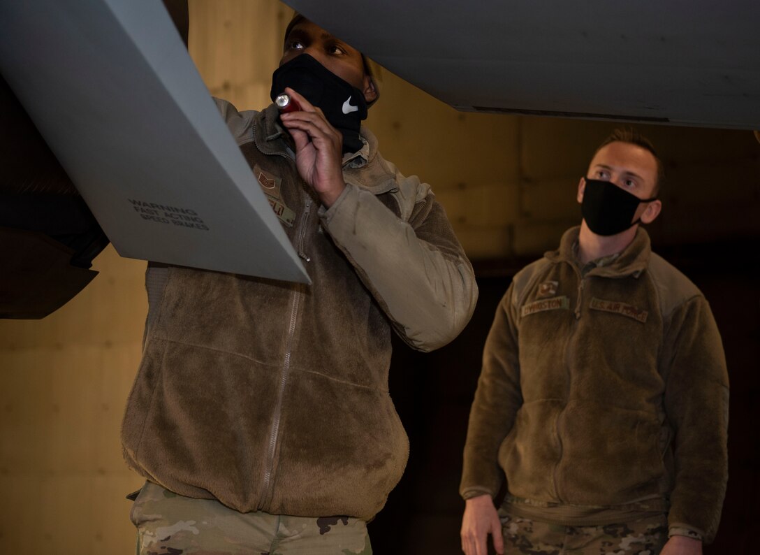 U.S. Air Force Tech Sgt. Jeremy Mayfield, 52nd Maintenance Squadron engine technician, left, and Staff Sgt. Joseph Livingston, 52nd Maintenance Group maintenance training instructor, begin a pre-flight inspection on an F-16 Fighting Falcon, Dec. 9, 2020, at Spangdahlem Air Base, Germany. Mayfield and Livingston were part of an Agile Combat Employment course where the students learned crew chief responsibilities, such as launch, recovery and refueling. (U.S. Air Force photo by Senior Airman Melody W. Howley)