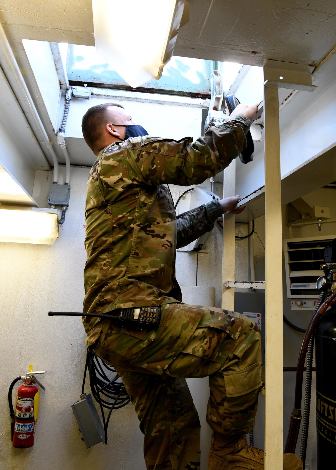 Tech. Sgt. Michael Reniewicz, 104th Fighter Wing power production shop leader, climbs out of a room containing arresting cables after performing routine maintenance December 10, 2020 at Barnes Air National Guard Base. (U.S. Air National Guard Photo by Airman 1st Class Camille Lienau