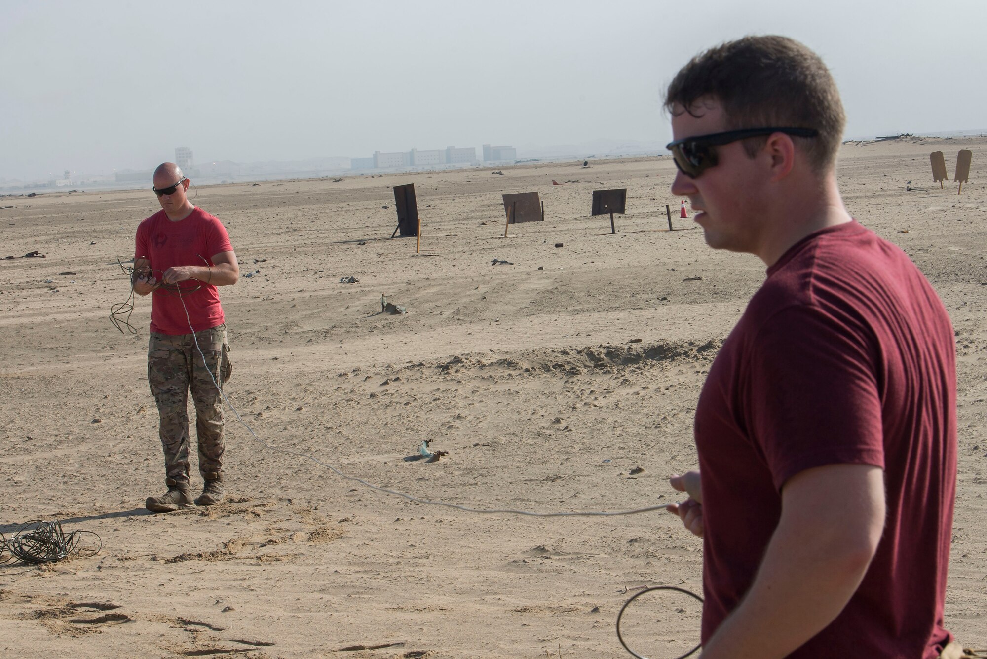 U.S. Air Force Staff Sgt. Brad Linville, 380th Expeditionary Civil Engineer Squadron (ECES) Explosive Ordnance Disposal (EOD) operations and administration noncommissioned officer (left), and Senior Airman Jordan Park, 380th ECES EOD technician (right), prepare a demolition system, remote and time (DSRT) device during an ammunitions disposition request (ADR) operation near Al Dhafra Air Base, United Arab Emirates, Dec. 5, 2020.