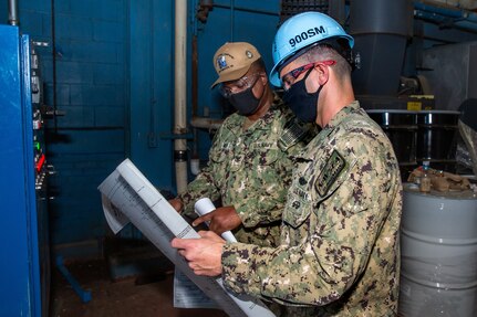 SurgeMain Sailors Chief Select Richard Palmer and Petty Officer Corey Jones re-putting in the values to reprogram one of the shop’s ovens.