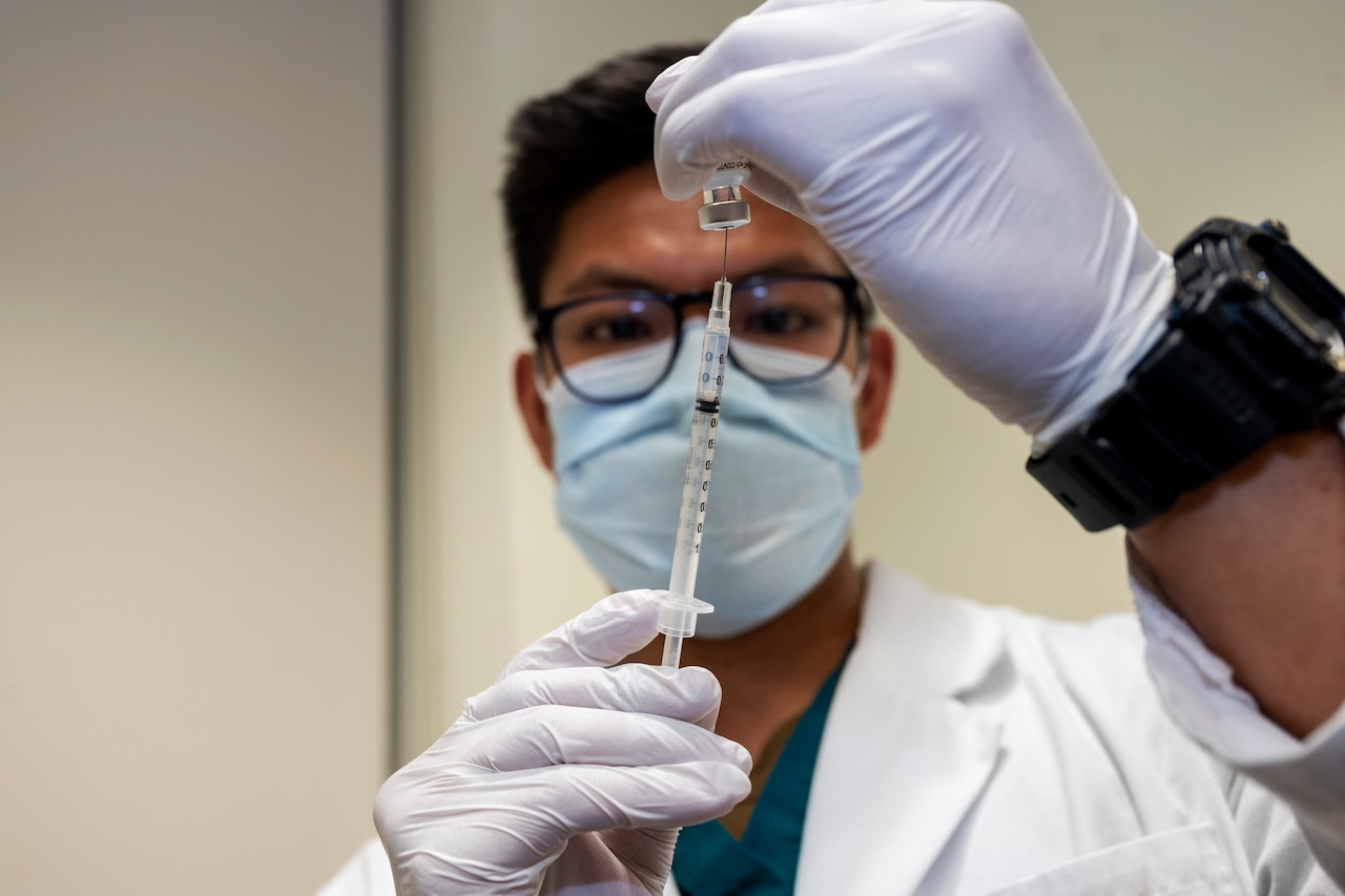 A Navy Seaman prepares a dose of the COVID-19 vaccine.